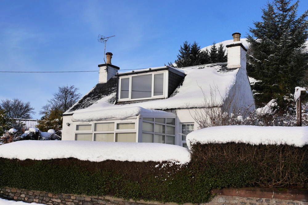 Half house cottage in the snow